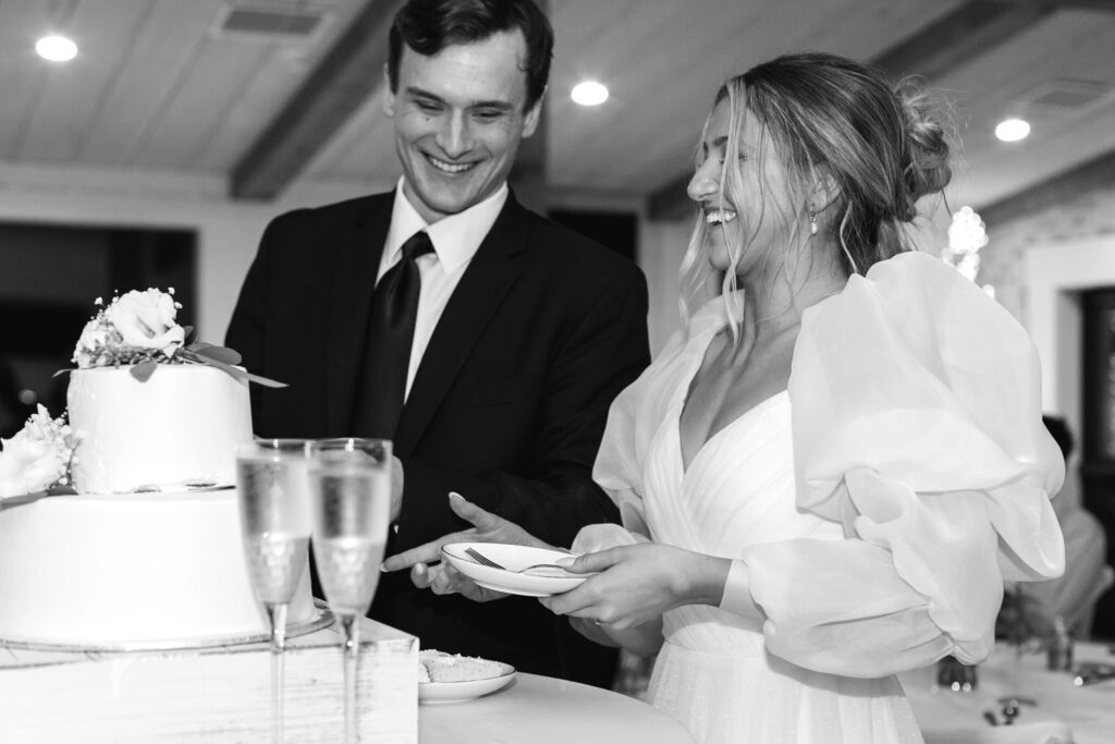 bride and groom smiling and cutting the cake